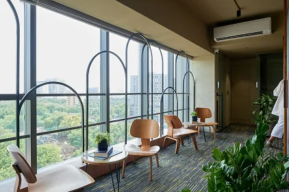 Coffee In-House Office — arched window lounge with Eames chairs and city skyline